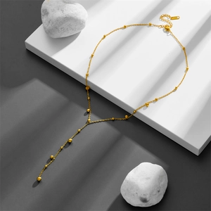 Elegant gold Y-shaped long tassel necklace with bead chain on geometric display