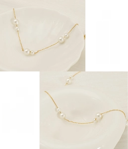 Macro view of 18K gold-plated stainless steel chain with round pearls and shells