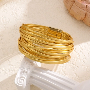 Detail of multi-strand gold faux leather wrap bracelet with magnetic metal clasp closure