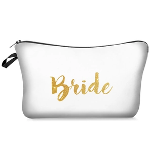 Detail of white bride makeup bag featuring gold glitter lettering and black zipper handle