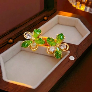 Vue macro de boucles d'oreilles fleur en cristal vert et blanc sur un écrin en velours