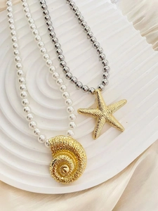Detailed macro view of gold starfish and conch pendants on pearl and silver bead necklaces
