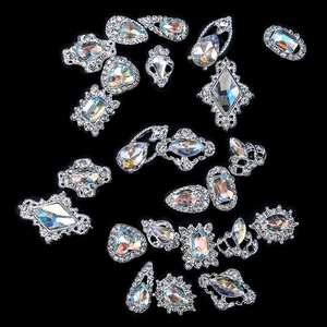 Mix of vintage silver alloy nail art charms with iridescent rhinestones on black background
