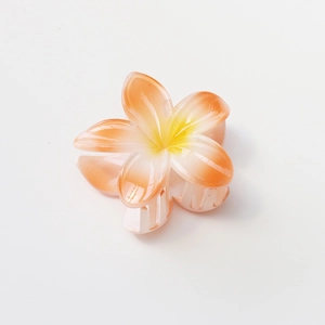 Detail of 8cm frangipani flower hair claw clip with orange gradient resin petals