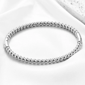 Macro view of polished stainless steel 5mm beaded bracelet with cylindrical clasp