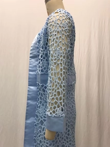 Gros plan du cardigan en dentelle au crochet bleu clair avec bordure en satin aux poignets