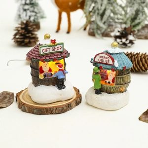 Détail de petites maisons de Noël lumineuses en résine sur un support en bois