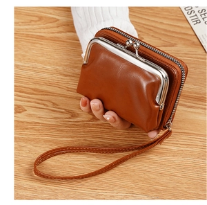 Detail of vintage brown leather kiss-lock coin purse with wristlet strap and zipper