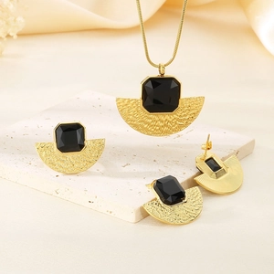 Dettaglio di un set di gioielli placcati oro 18K con pietre nere su pietra