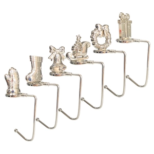 Detailed view of six silver metal Christmas stocking hooks with festive holiday motifs