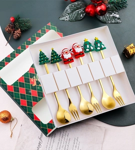 Detail of Christmas stainless steel cutlery set with cartoon Santa and tree toppers