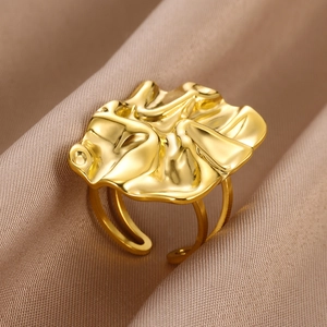 Macro shot of an adjustable gold pleated wave ring on a luxury brown silk background