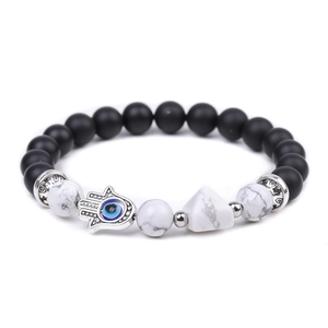 Detail of beaded Hamsa hand bracelet with matte black beads and evil eye charm
