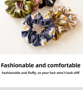 Detailed view of daisy print satin scrunchies in various vintage colors and silk texture