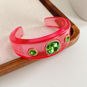 Macro shot of vintage resin bangle with emerald crystal and rhinestone detail