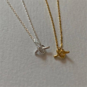 Macro detail of 925 sterling silver knotted pendants in gold and silver finishes