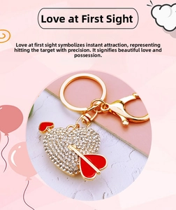Close-up of heart and arrow keychain with sparkling rhinestones and red enamel details