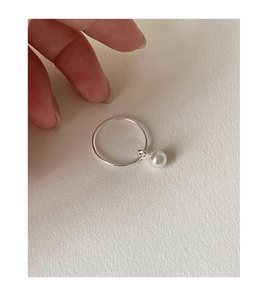 Close-up of 925 sterling silver ring featuring a white pearl pendant on a minimal band