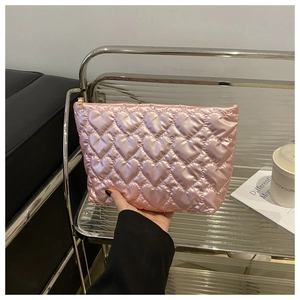 Detailed view of pink heart-quilted makeup bag with glossy texture and metal zipper