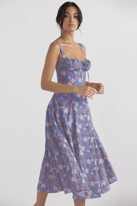 Detailed close-up of a blue floral slip dress featuring tie-up neckline and pleat details
