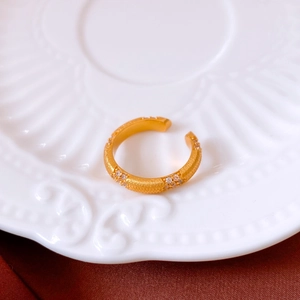 Gros plan sur une bague vintage dorée brossée avec des zircons et des détails fins