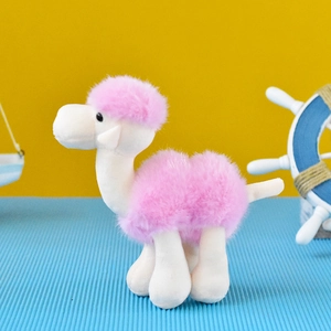 Macro detail of a cute pink and white plush camel keychain with soft and fluffy faux fur texture