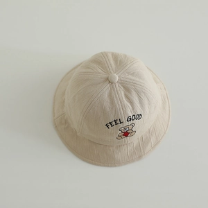 Detail of baby sun hat with cute brown bear embroidery and feel good text on beige cotton
