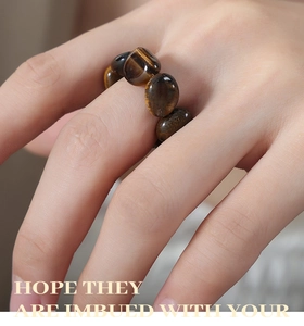Macro shot of tiger eye stone beaded ring with golden brown texture on elastic band