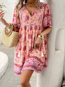 Detail of pink bohemian dress featuring floral paisley print and tassel drawstring waist