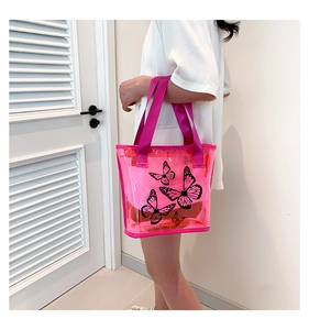 Detail of neon pink transparent PVC beach tote featuring black butterfly print