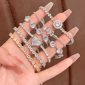 Elegant zircon heart and bow pearl bracelets set shown on model against brown leather