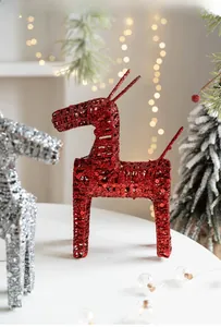 Macro shot of red and silver glitter reindeer figurines for festive tabletop decoration