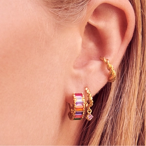 Detail of gold ear cuff and huggie earrings with rainbow baguette stones and purple zircon