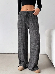 Detail of high waisted wide leg trousers featuring dark grey ribbed knit and drawstring