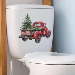 Detail of red Christmas truck toilet sticker with tree on white bathroom tank background