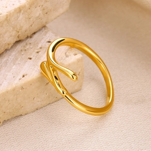 Macro detail of gold plated organic drop ring on textured beige stones and fabric
