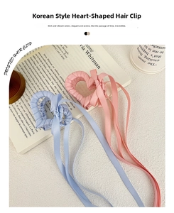 Dettaglio di fermagli per capelli a cuore in nastro rosa e blu con lunghi fiocchi