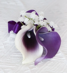 Macro detail of artificial purple Calla Lily corsage with lace and satin ribbon