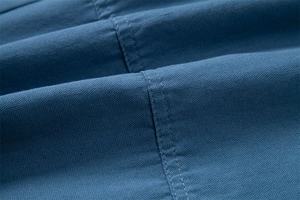 Macro shot of blue cotton fabric showing precise stitching and durable texture on men's shorts