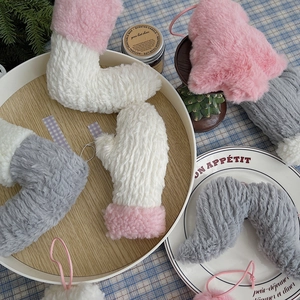 Moufles en peluche douce aux couleurs pastel sur un fond hivernal rustique et cosy