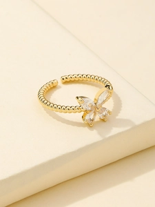 Detail view of a golden bow ring featuring sparkling marquise-cut zircon stones