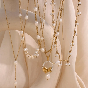 Detail of 18K gold plated pearl necklaces with baroque pearls and golden bow pendant