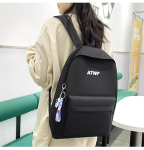 Close-up of black ATWF backpack featuring a cute astronaut pendant and buckle detail