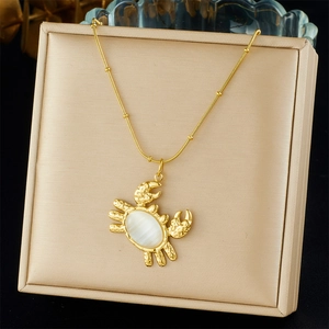 Collar con colgante de cangrejo dorado y piedra blanca con cadena de serpiente