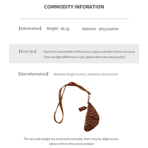 Detail view of leopard print faux leather croissant pendant with alloy chain and leather strap