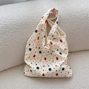 Detail of winter embossed tote bag featuring cute cartoon bears and Christmas motifs