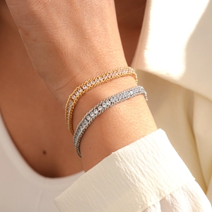 Close-up of gold and silver chain link bracelets with sparkling crystal inlay on wrist