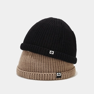Gros plan de bonnets en maille côtelée noire et marron clair avec écusson lettre N pixel