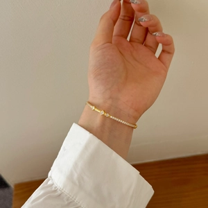 Close-up of golden Mobius bracelet featuring sparkling zircon stones on a female wrist