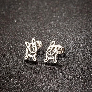 Détail de boucles d'oreilles carlin en acier inoxydable poli sur surface texturée sombre